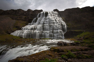 Scenic view of waterfall against sky