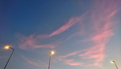 Low angle view of illuminated street light against sky