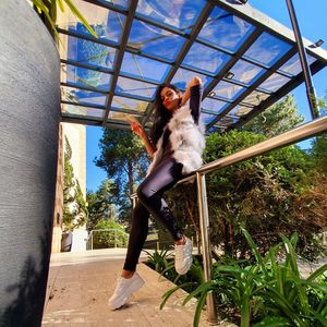 Portrait of young woman against plants