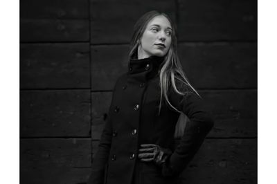 Young woman standing against wall