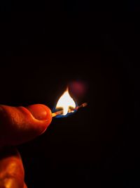 Close-up of hand holding burning candle