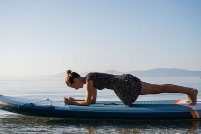 Woman in sea against clear sky