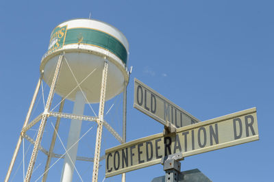 Low angle view of information sign against clear blue sky