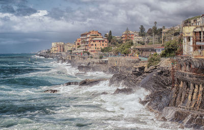 Panoramic shot of sea and buildings against sky