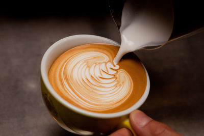 Cropped image of person making cappuccino