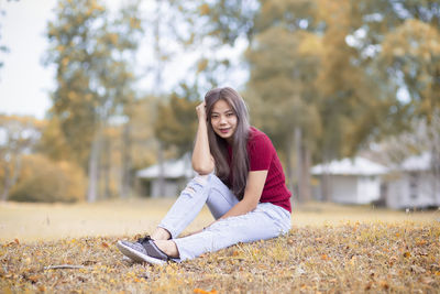 Young woman sitting on plant during autumn
