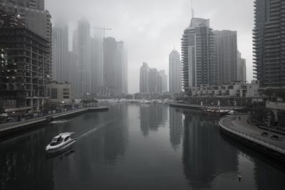 River amidst buildings in city against sky