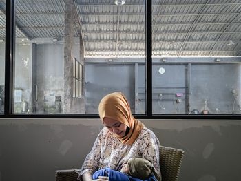 Midsection of woman sitting in glass window