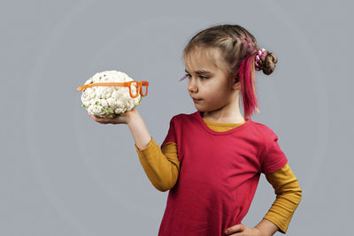 Girl eating food against white background