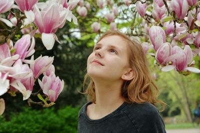 Close-up of girl looking at flowers in park