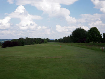 Scenic view of golf course against sky