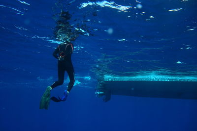 Low section of woman scuba diving undersea