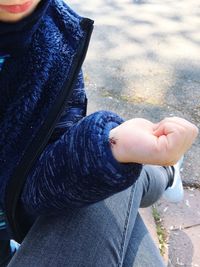 Low section of woman sitting outdoors