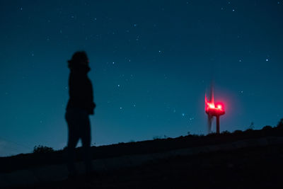 Silhouette person standing against sky at night