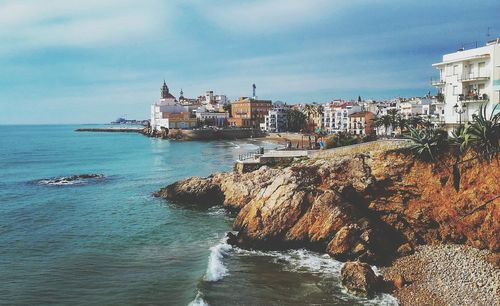 Scenic view of sea by city against sky