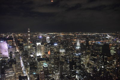 Illuminated cityscape against sky at night