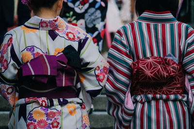 Rear view of women in kimono walking on street