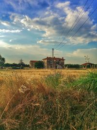 View of field against cloudy sky