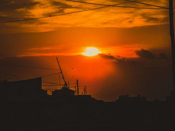 Silhouette buildings against sky during sunset