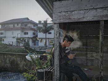 Rear view of young man standing against building