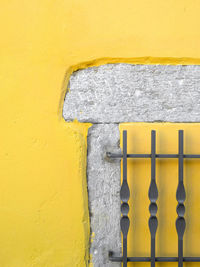 Metal grate against yellow wall