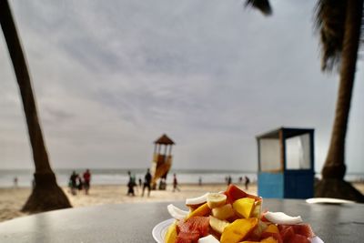 People on beach by sea against sky