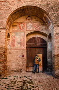 Full length of man working at entrance of historic building