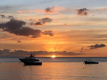 Silhouette boat in sea against sky during sunset