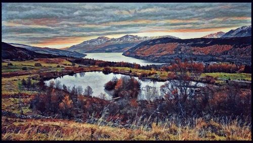 Scenic view of lake by mountains against sky