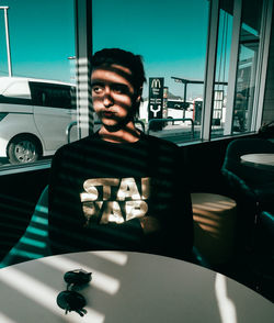 Portrait of young woman sitting on wall