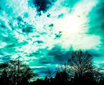 Low angle view of silhouette trees against sky