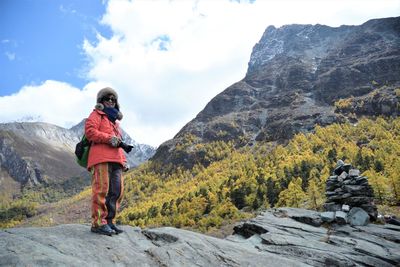 Full length rear view of man walking on mountain against sky