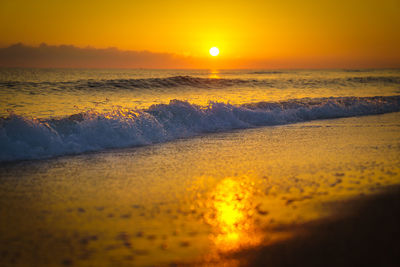 Scenic view of sea against orange sky