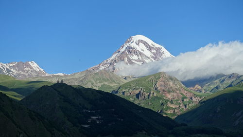 Scenic view of snowcapped mountains against clear blue sky