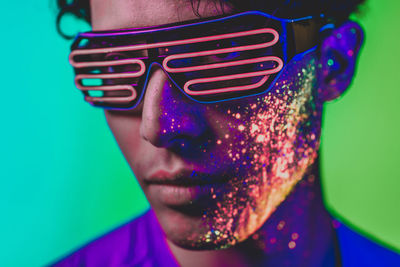 Close-up of man with multi colored face paint wearing eyewear