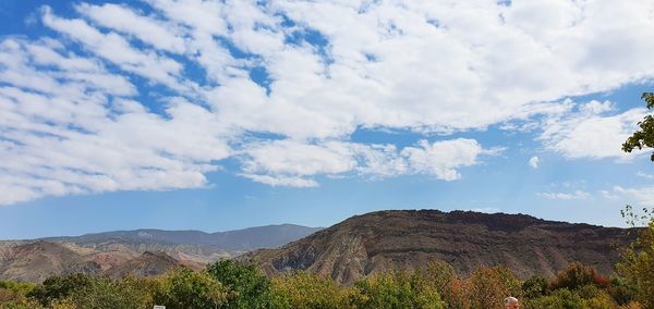 Scenic view of land and mountains against sky