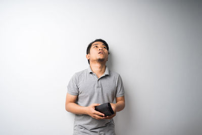 Young man using mobile phone against white background