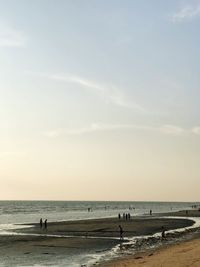 People on beach against sky