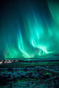 Scenic view of snow covered field against sky at night