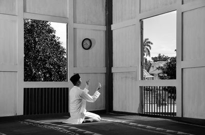 Rear view of woman sitting outside building