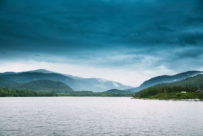 Scenic view of lake by mountains against sky