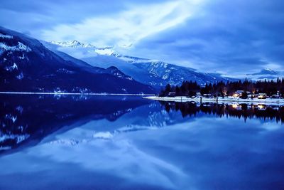 Scenic view of lake and mountains against blue sky