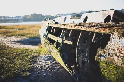 Abandoned boat on beach against sky