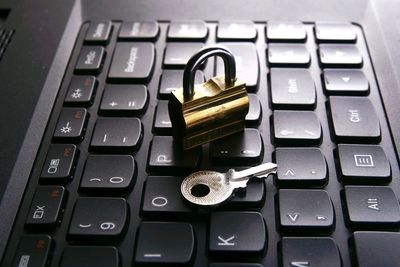 Close-up padlock and key on of computer keyboard