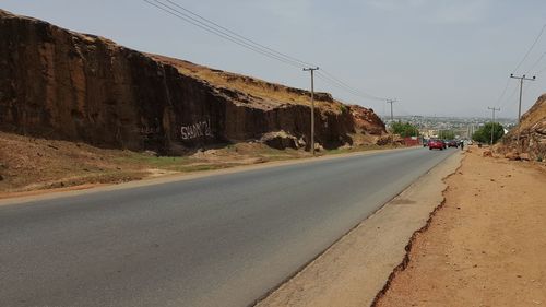 Cars on suburb road against clear sky