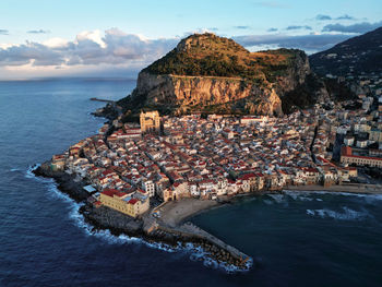 High angle view of townscape by sea against sky