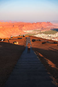 Rear view of people walking on road