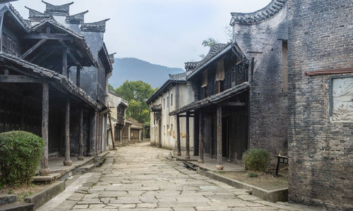 Footpath amidst buildings against sky