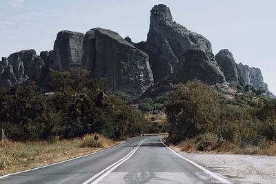 Road by rock formation against sky