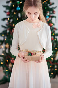 Portrait of teenage girl standing against tree